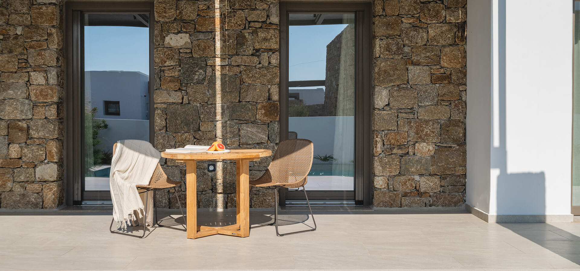 Outdoor wooden table and chairs by the stone wall