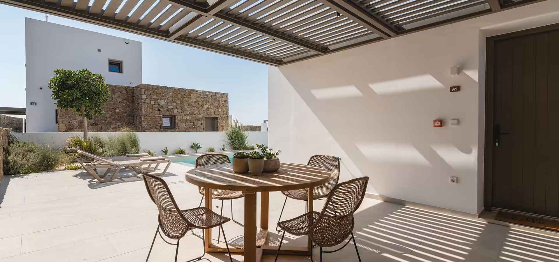 Outdoor wooden table and chairs under a pergola